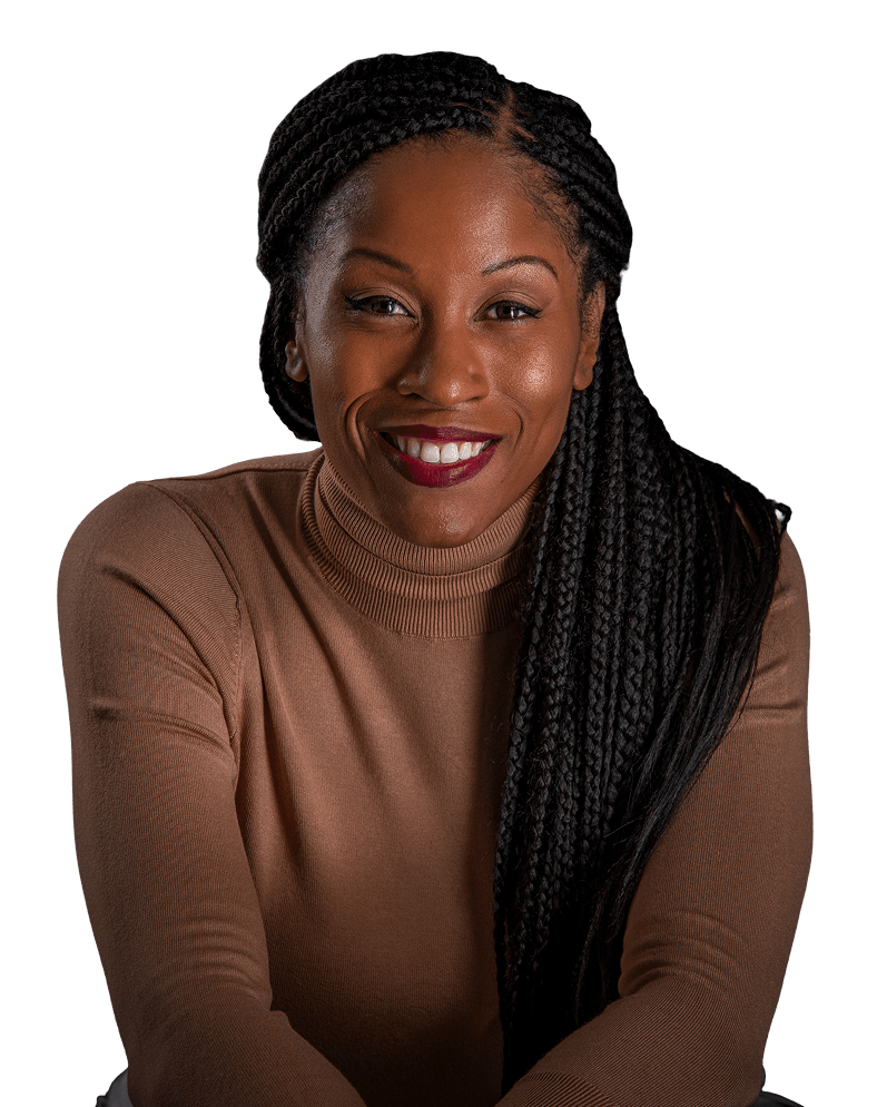 Julia Rock les confidently with arms crossed, wearing a tan turtleneck and sporting long braids, posed against a dark backdrop.